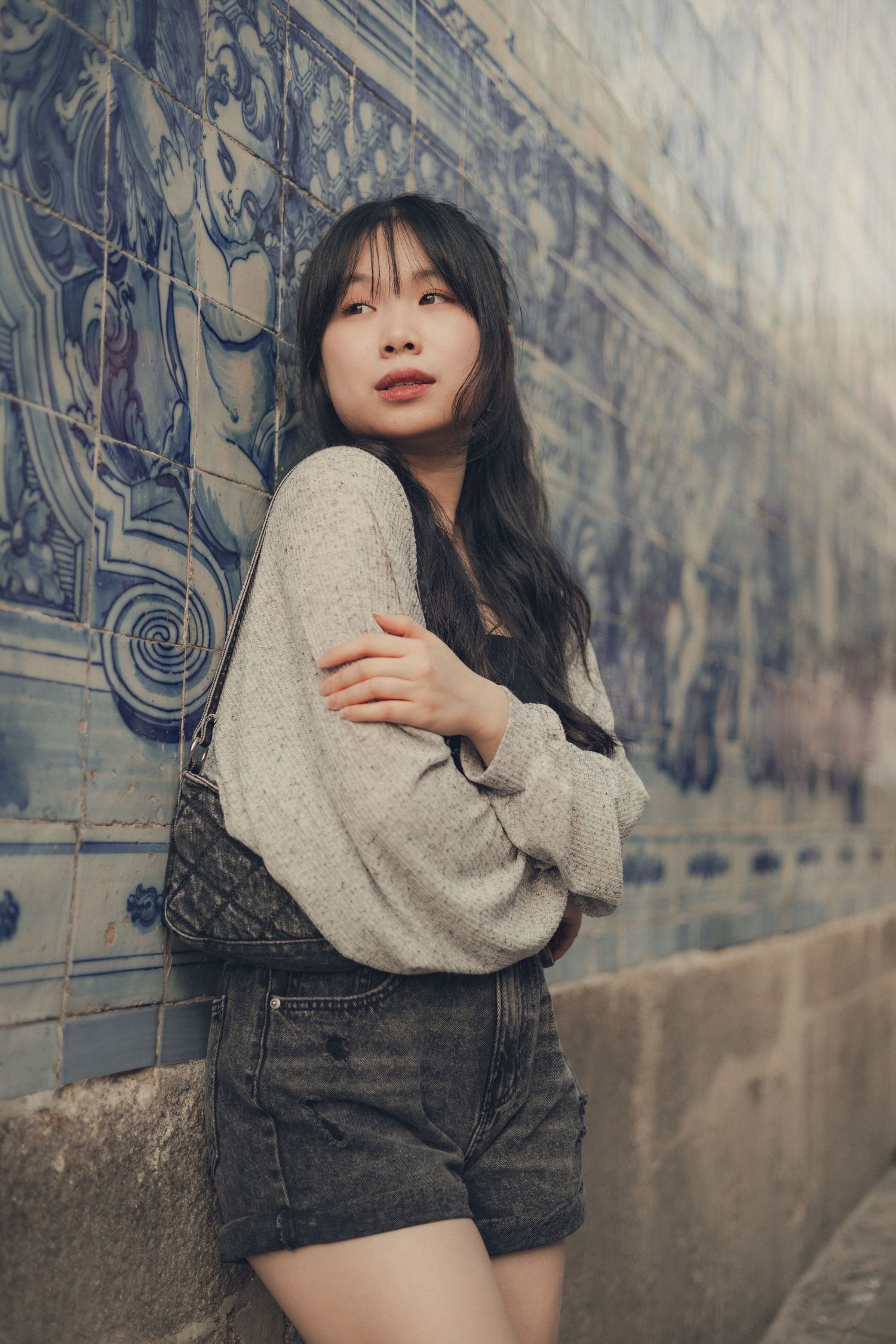 Artistic portraits showcasing fashion against a blue tiled wall background.