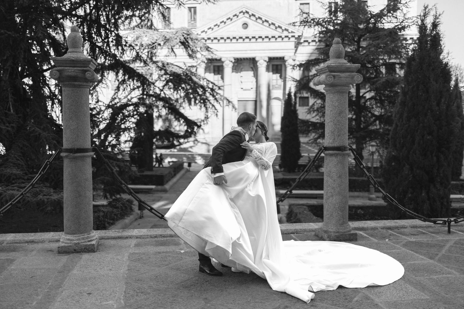 Black and white image of wedding celebration with confetti falling around silhouetted figures outside.