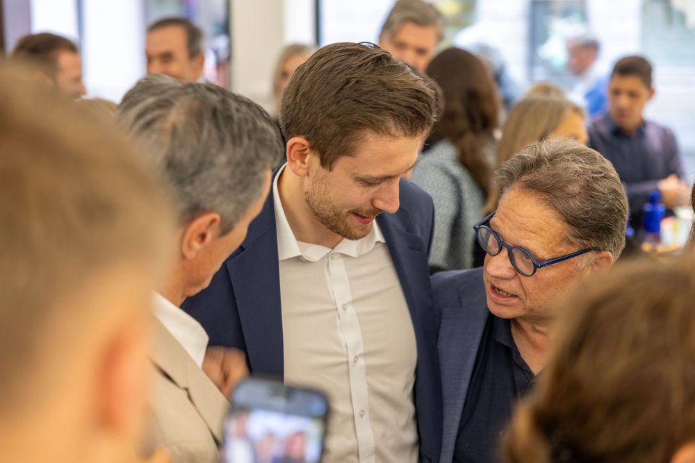 Business professionals network and mingle during an indoor social gathering.