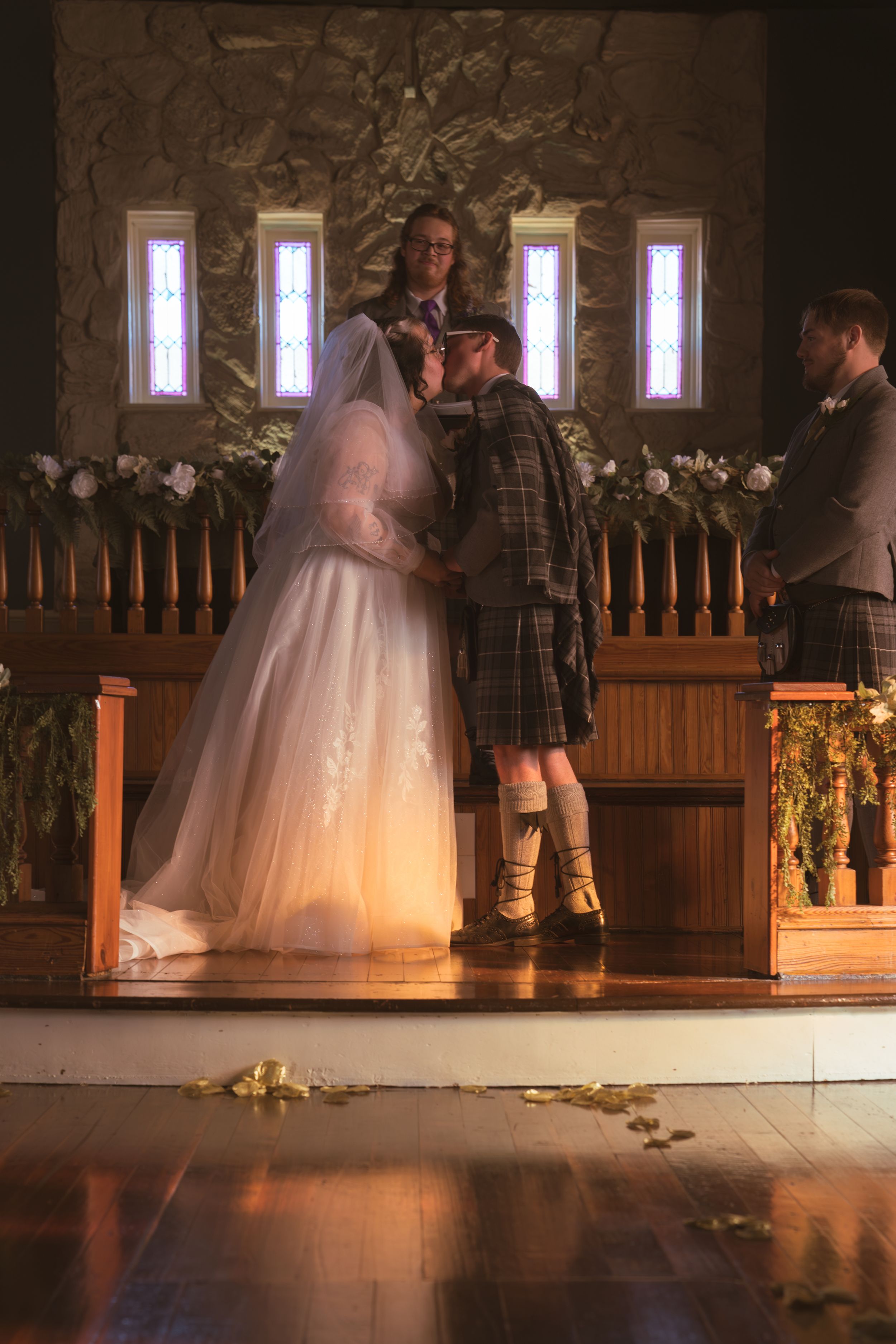 Wedding ceremony venue with white floral decorations and illuminated windows creating a romantic atmosphere.