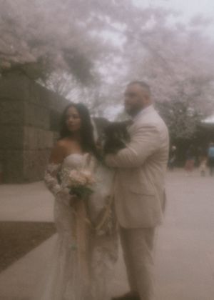 A dreamy, soft-focus wedding photo captured under cherry blossom trees.