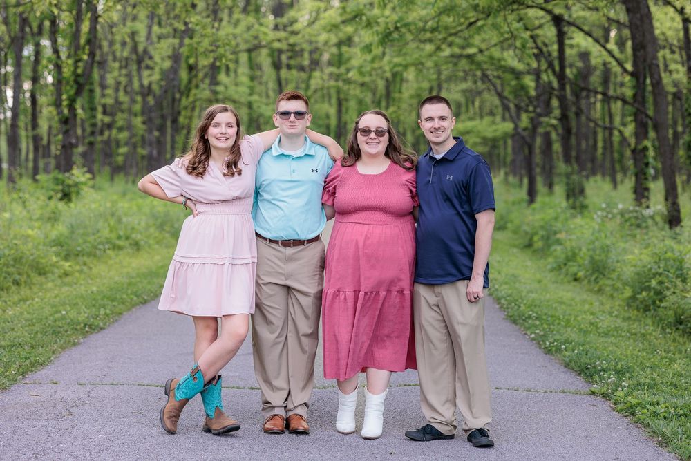 Siblings lined up on a forest trail wearing coordinated spring outfits.