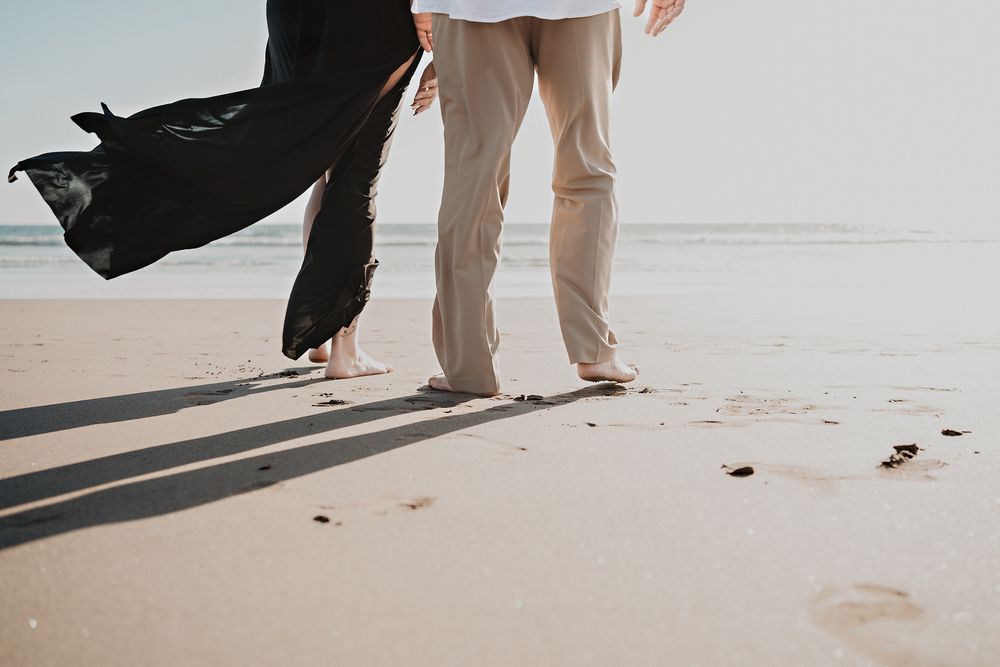 Fotografía artística de piernas caminando hacia el mar en la playa
