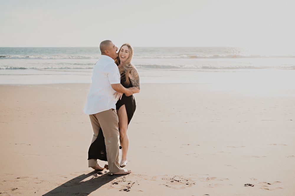 Pareja abrazada y sonriendo, momentos divertidos en la playa