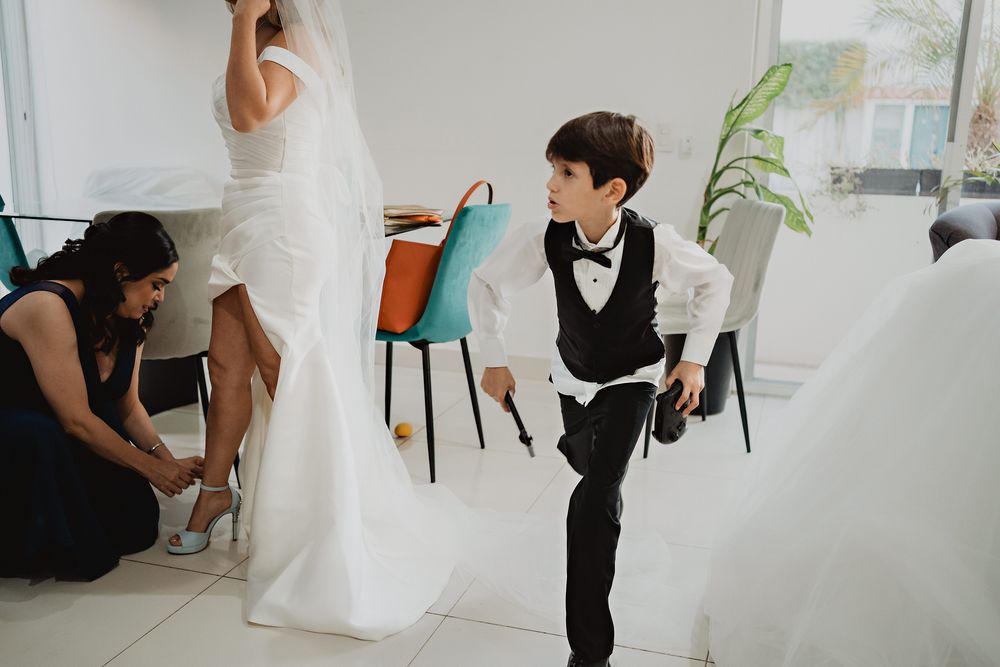 Sobrino jugando y saltando sobre el vestido de novia