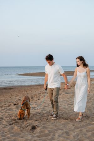 couple walking hand in hand on the beach Shediac photographer engagement photos romantic beach date night sunset golden hour photos Cap Pele