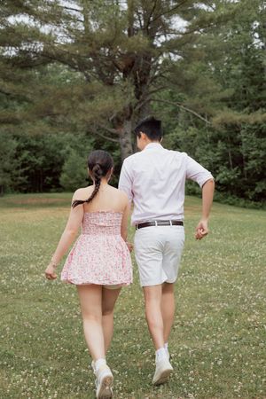 Couple run hand in hand during candid moment photography surprise engagement proposal photoshoot in Moncton New Brunswick, freelance photos