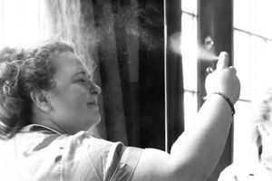 A series of black and white photographs in a horizontal strip showing someone kissing through glass panes.