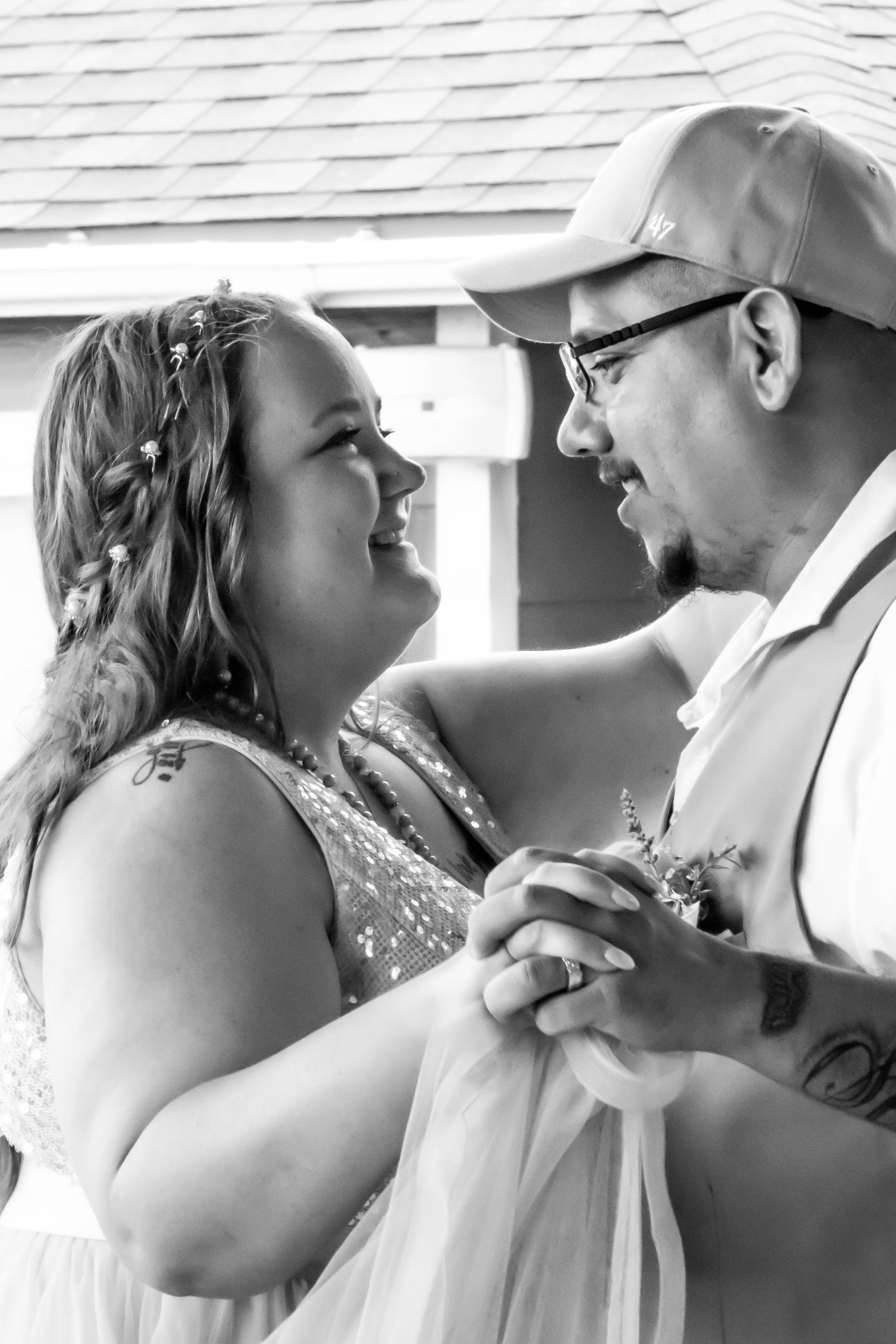 A happy couple shares an intimate moment during their first dance at their outdoor wedding celebration.