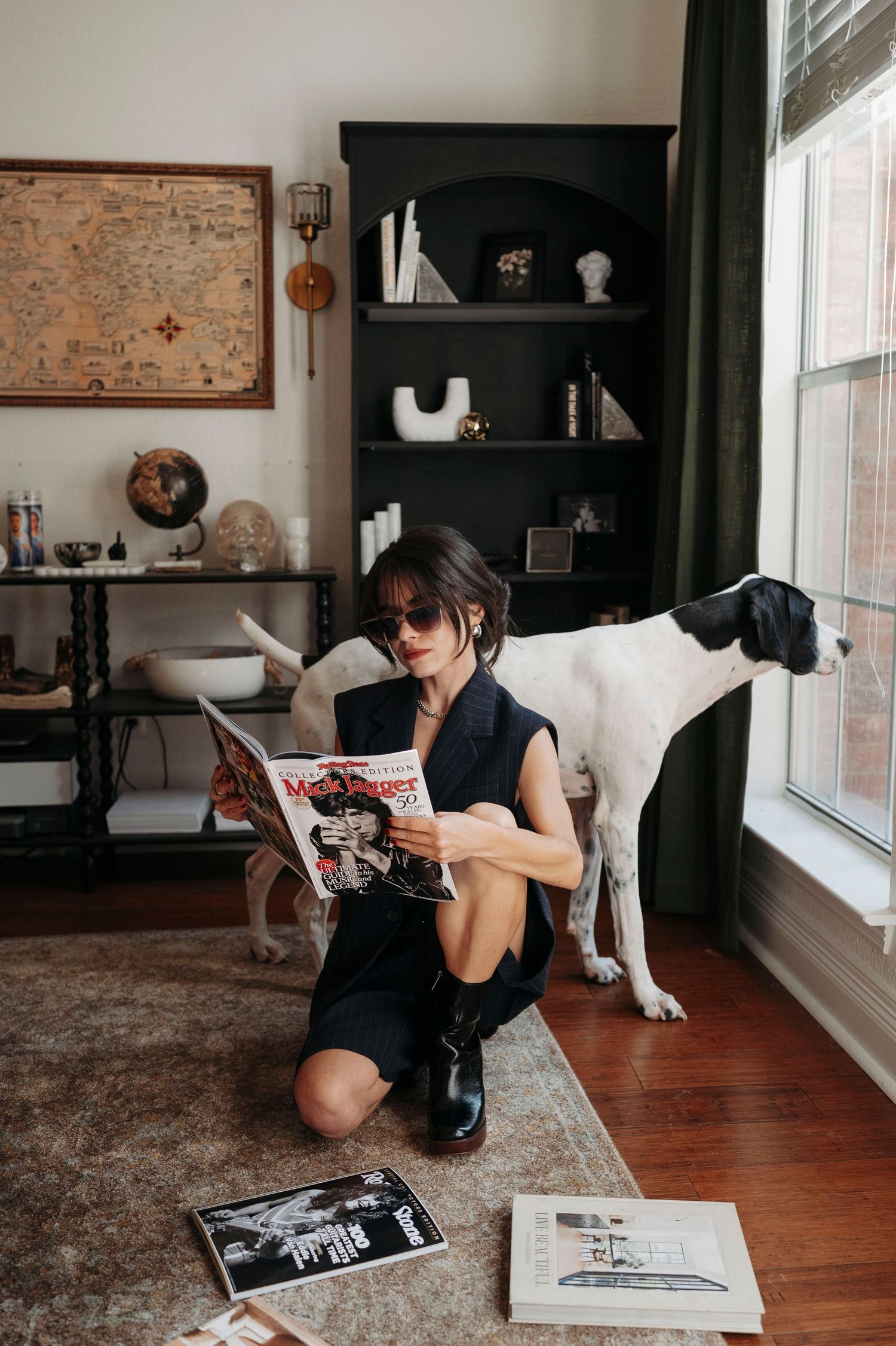 Lifestyle photos of someone reading magazines on hardwood floor with cat nearby.