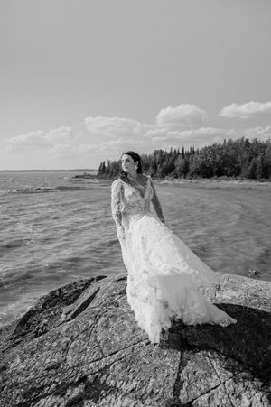 A black and white panoramic sequence shows a flowing white dress against dramatic rocky coastal scenery.