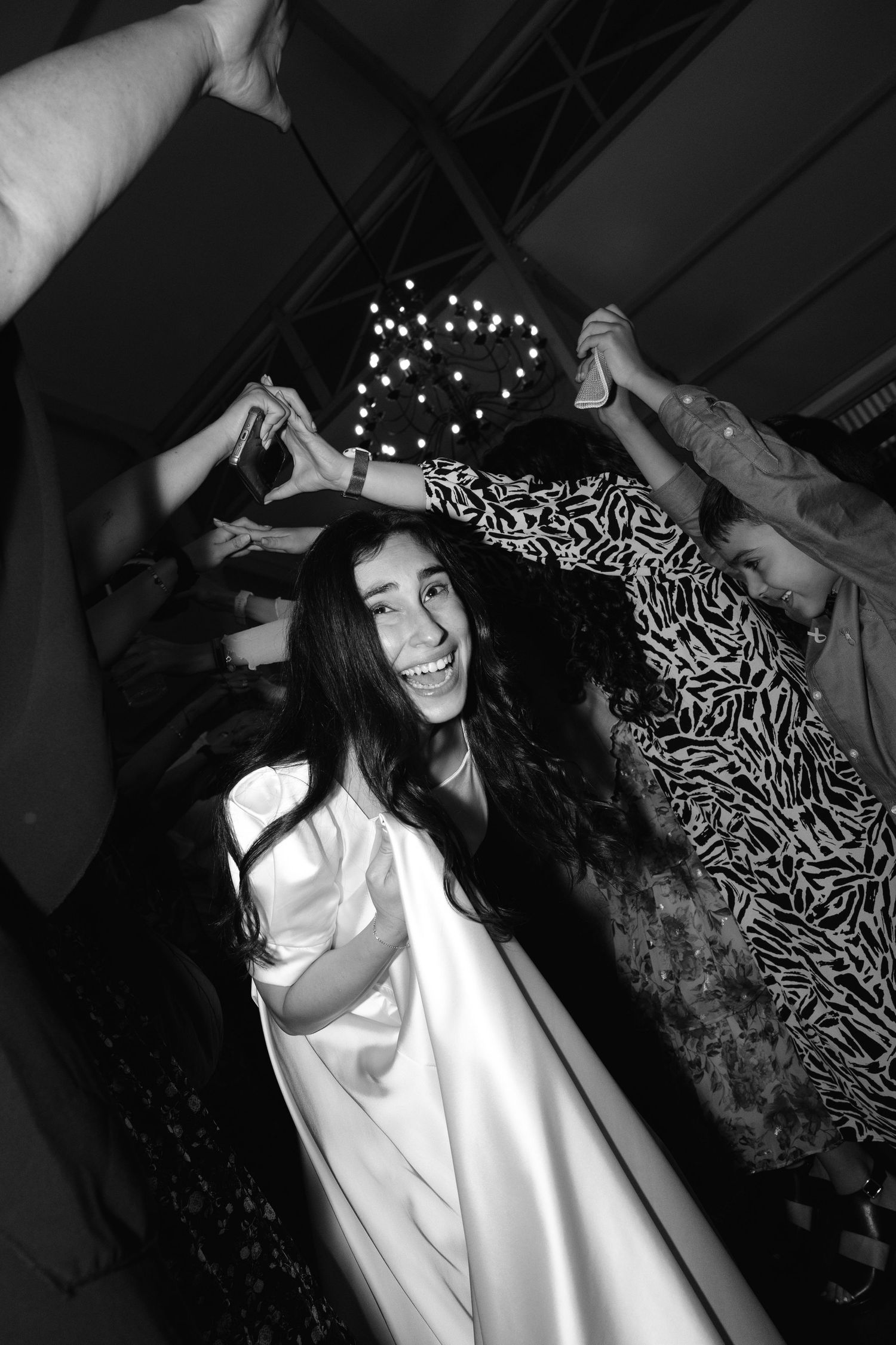 Black and white photos showing dance party moments with string lights in the background.
