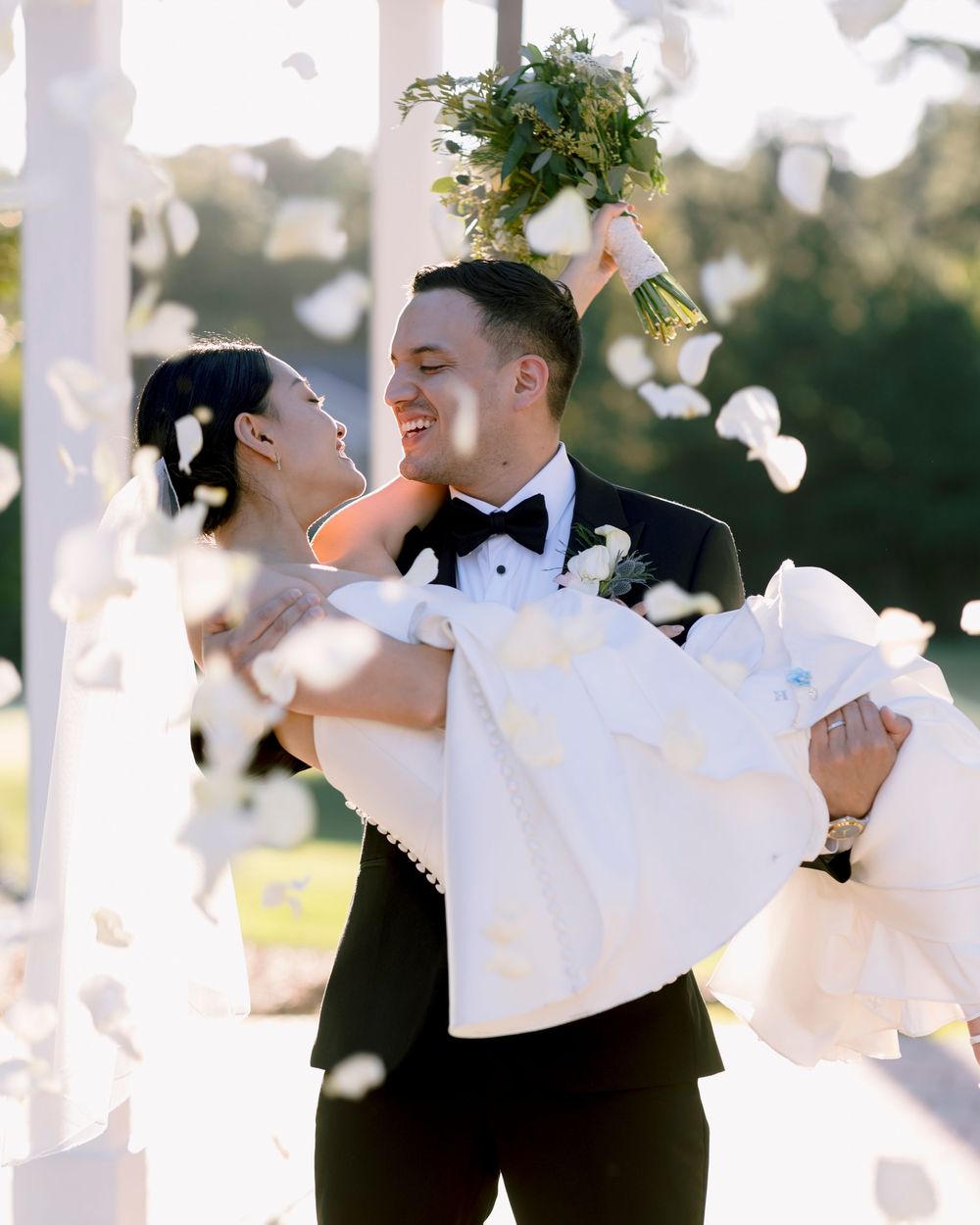 Romantic wedding couple portraits with flowing veil in bright sunlight.