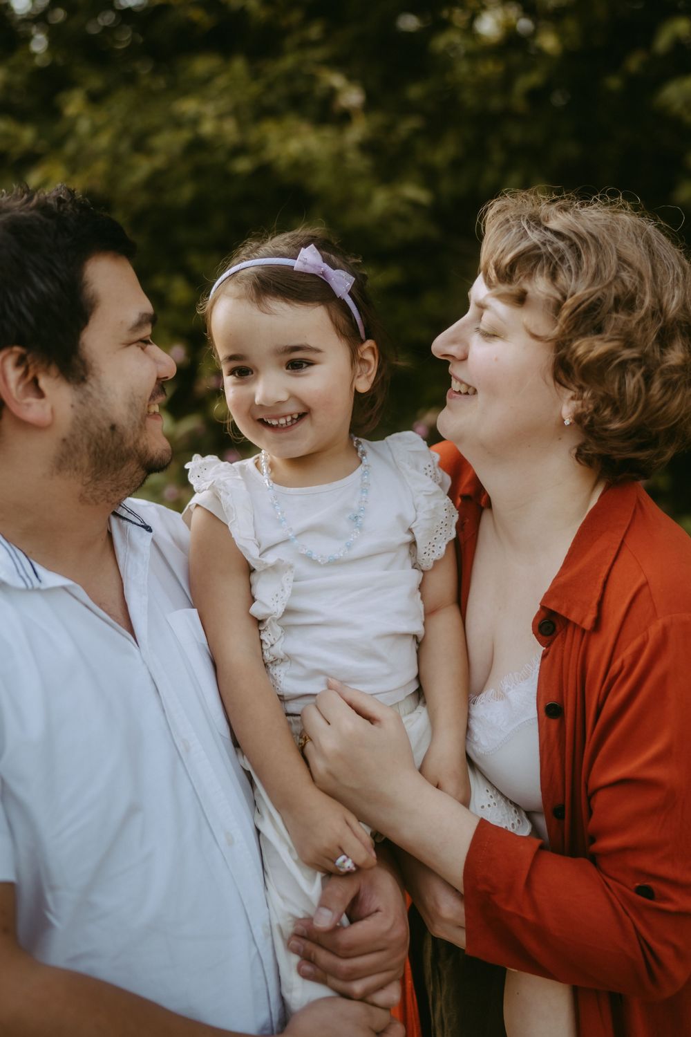 Joyful family sharing an intimate moment together against a blurred natural background.