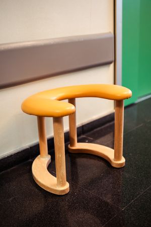 Close-up view of wooden mushroom-shaped massage tool on dark surface.