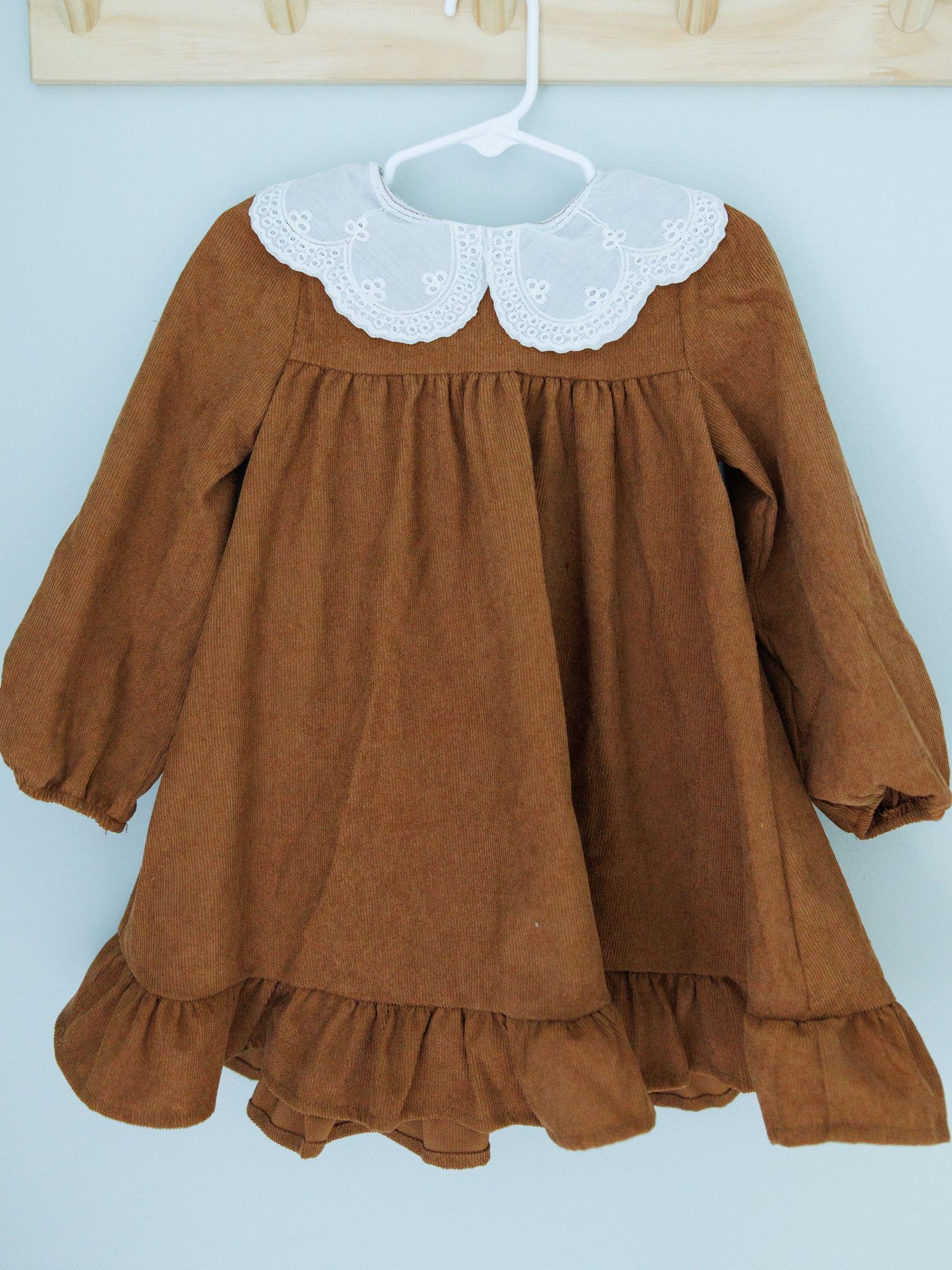 Stylish kids outfit featuring gray button-down shirt with floral bow tie, navy suspenders and khaki shorts.