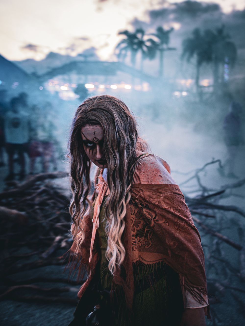 Spooky horror character with long hair in atmospheric foggy setting with palm trees at dusk.