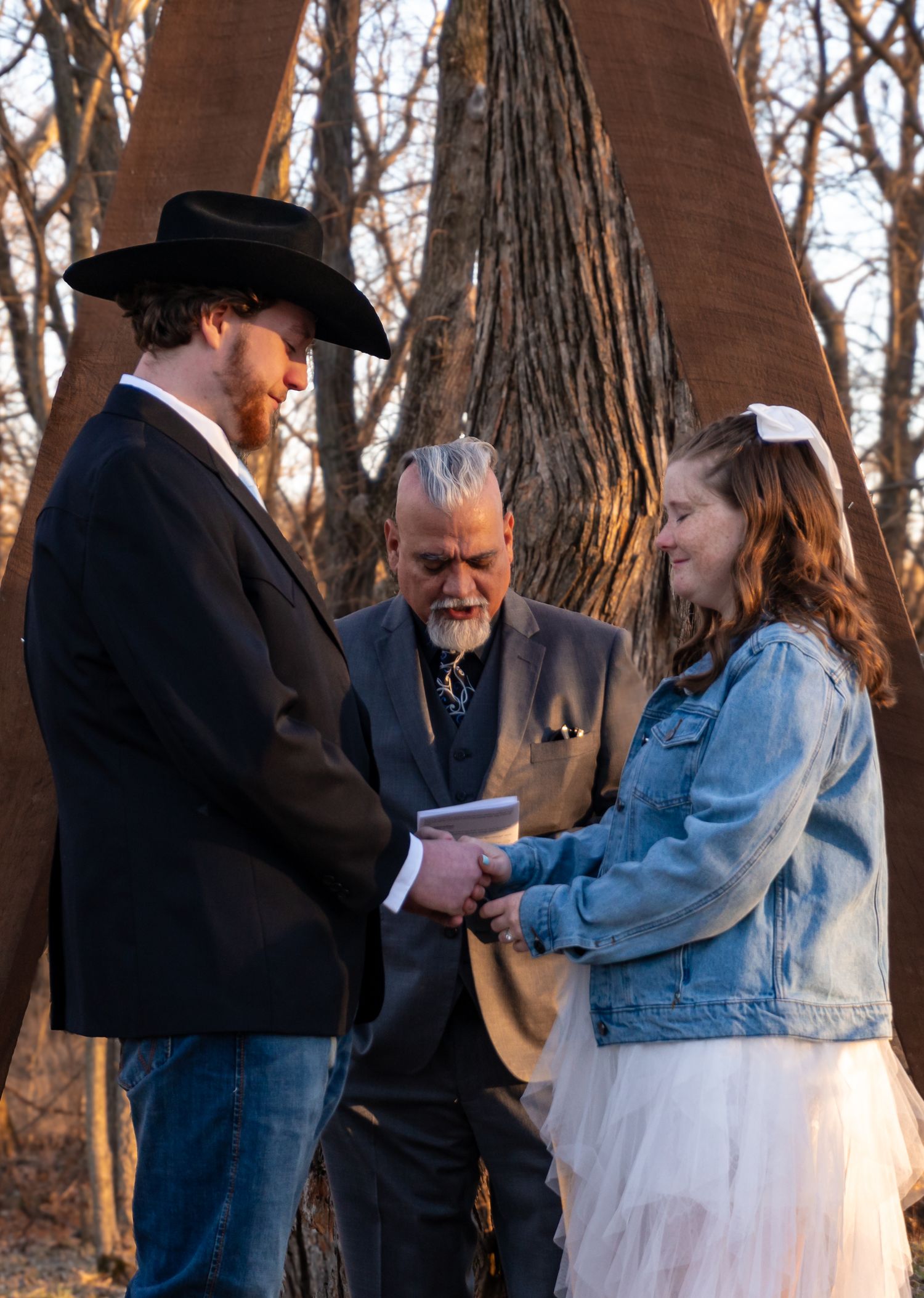 A couple with their pastor at the alter, getting married in the winter.