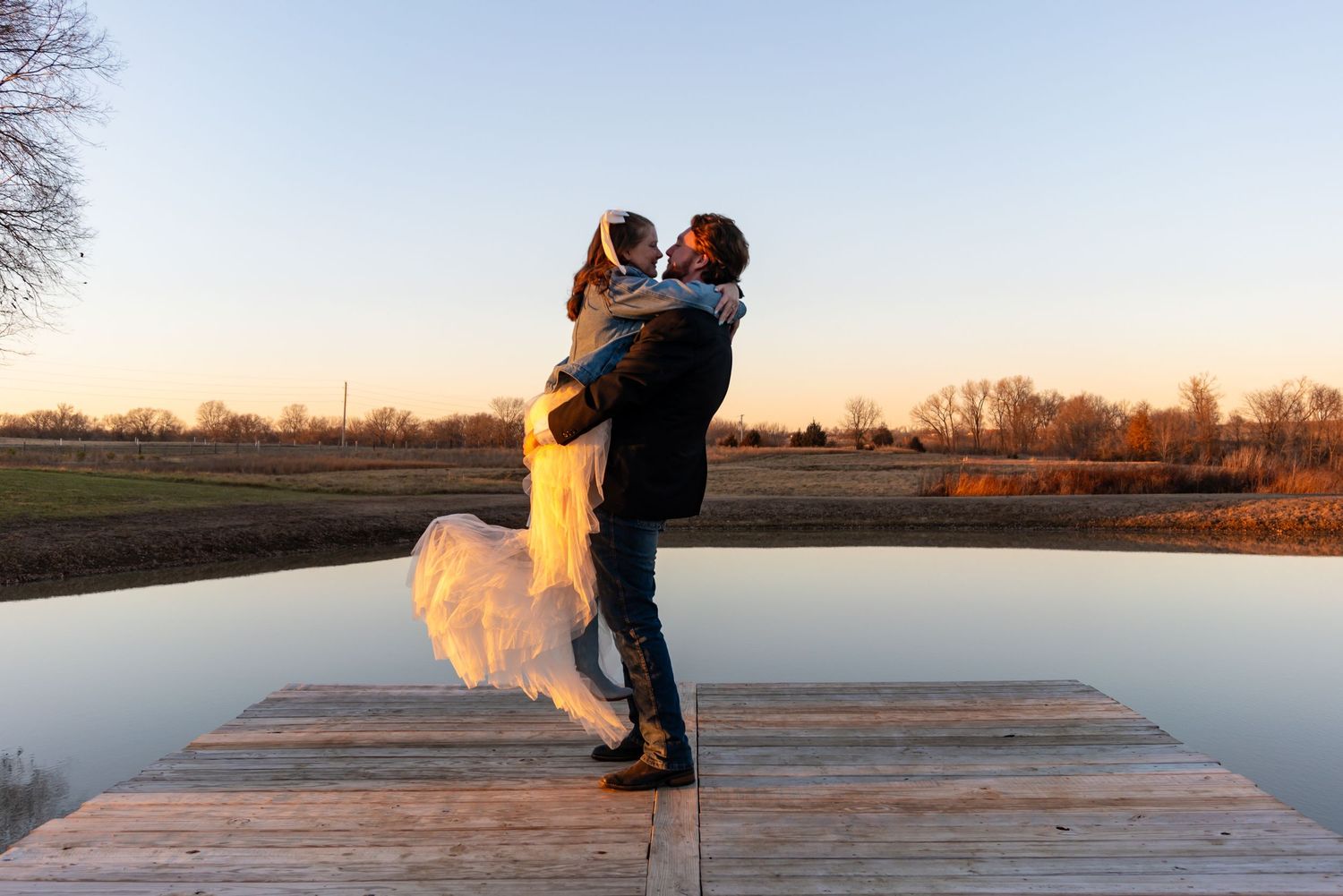 A couple standing on the dock at Hazel Hill Farm celebrating their marriage.