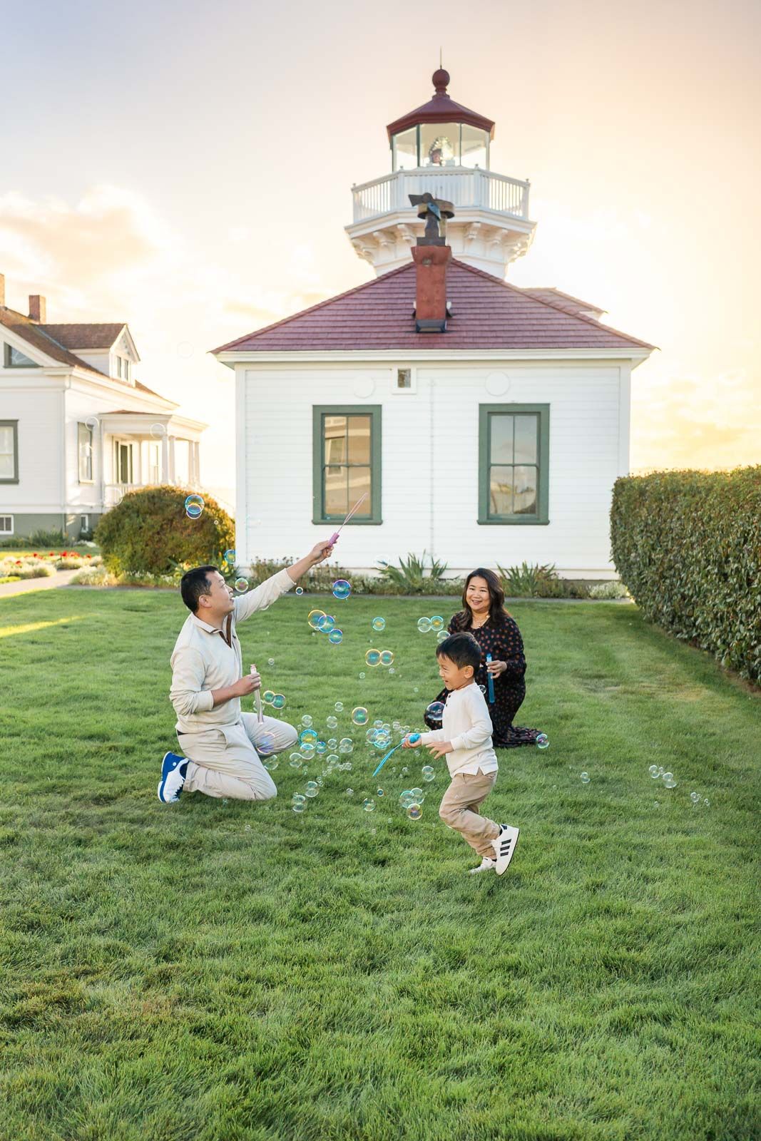 Family playing with bubbles by the lighthouse in Mukilteo.