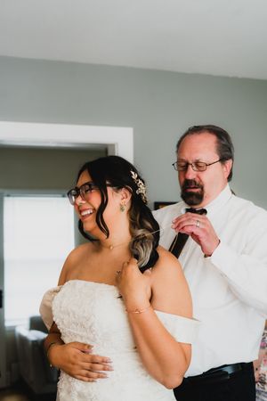 A tender moment shared during wedding preparations in a bright room.
