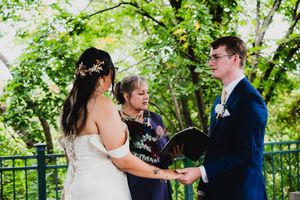 Wedding party members share candid moments on a garden pathway.