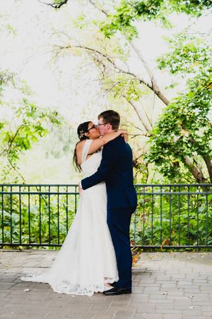 Romantic wedding portraits captured under a garden pavilion with lush greenery.