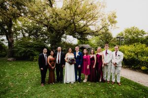 Wedding party group photo outdoors with pink and gray color scheme.