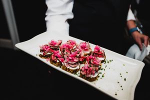 A sequence of images showing pink-topped sushi rolls being plated and served on white dishes.