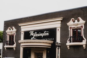 Row of classic storefronts with white decorative moldings and 'The Lexington' signage on brick facade.