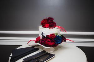 Red and blue flower arrangements displayed on white surfaces against a dark background.