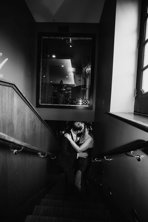 Dramatic black and white hallway scene with silhouetted figures and geometric shadows.