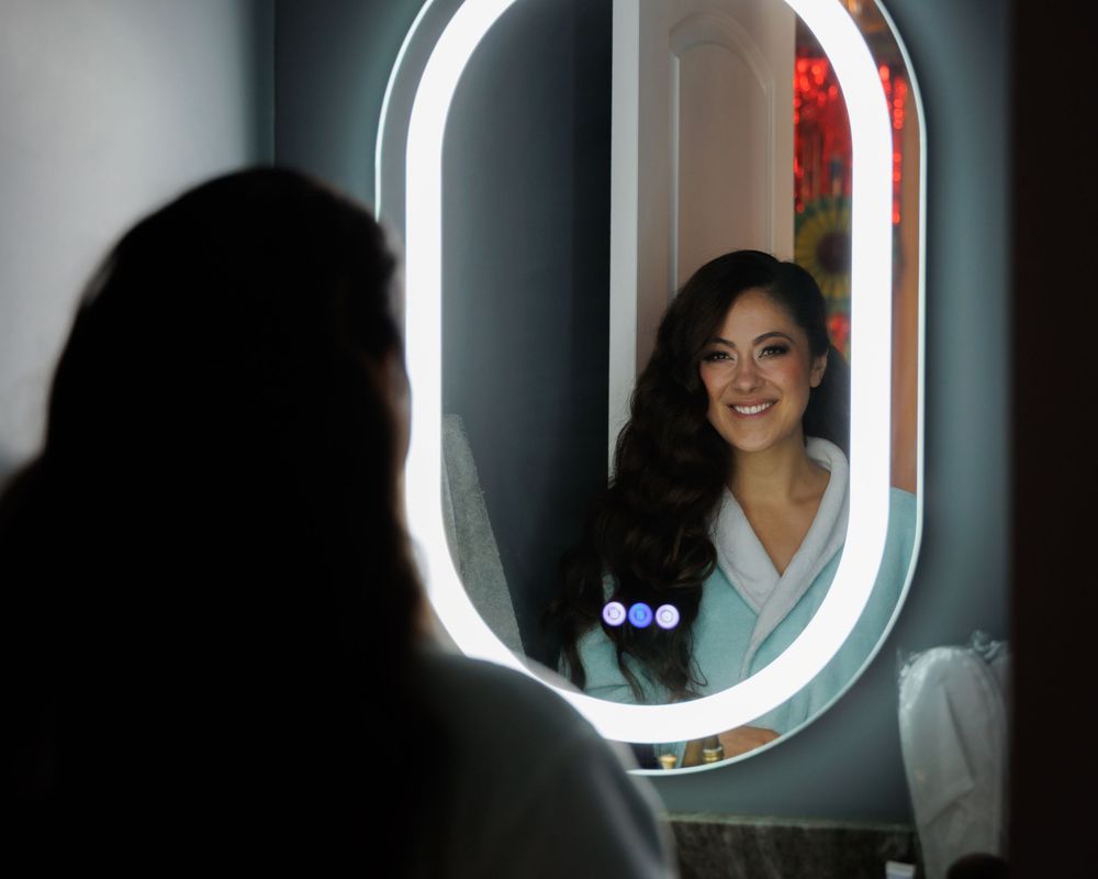 A series of illuminated round mirrors show reflections of someone posing in different angles and positions.