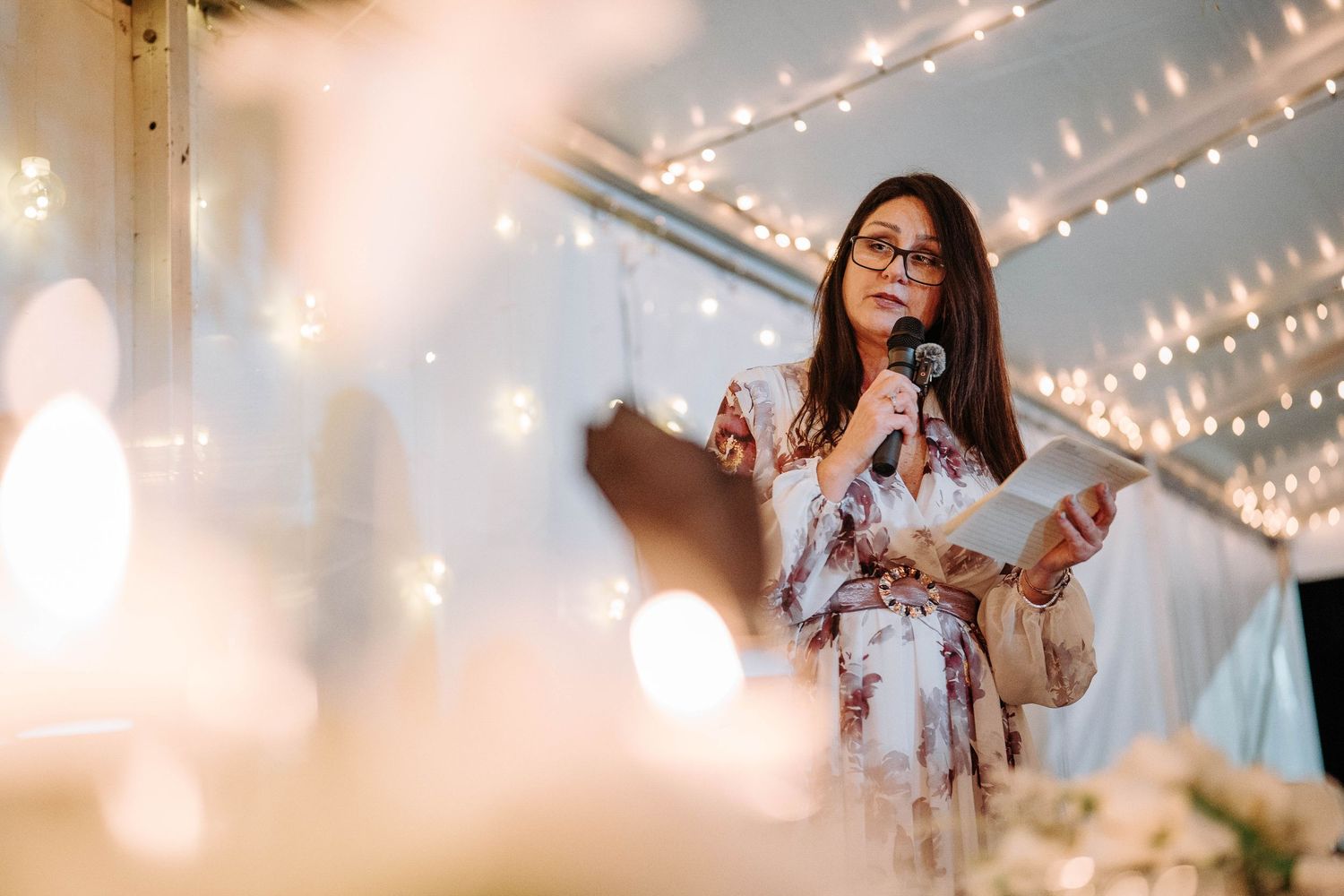 A wedding reception venue decorated with twinkling string lights creating a warm, romantic atmosphere.