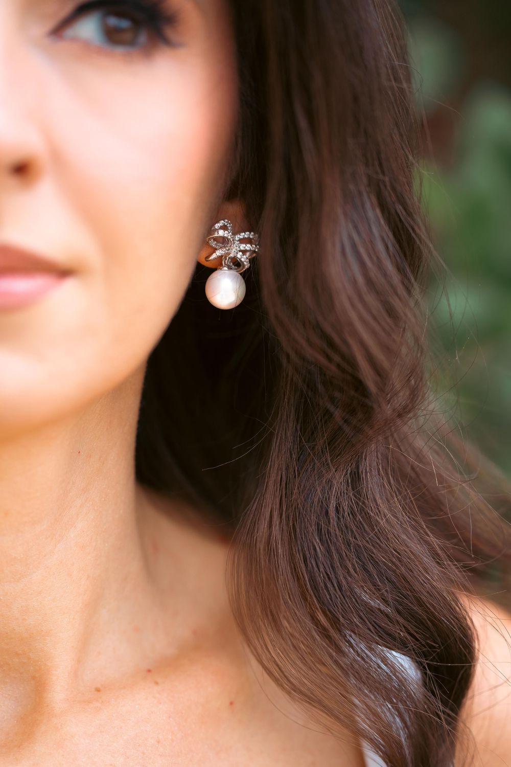 Close-up detail of sparkly earrings and elegant jewelry.