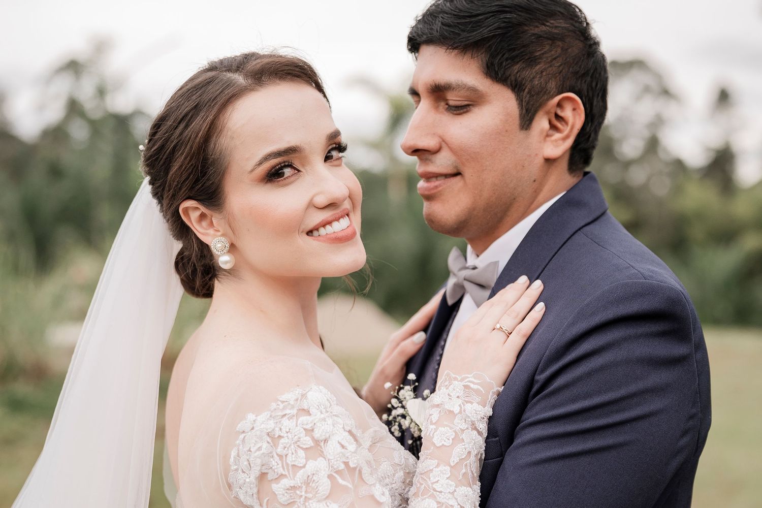 Elegant wedding couple shares intimate moment during outdoor portrait session.