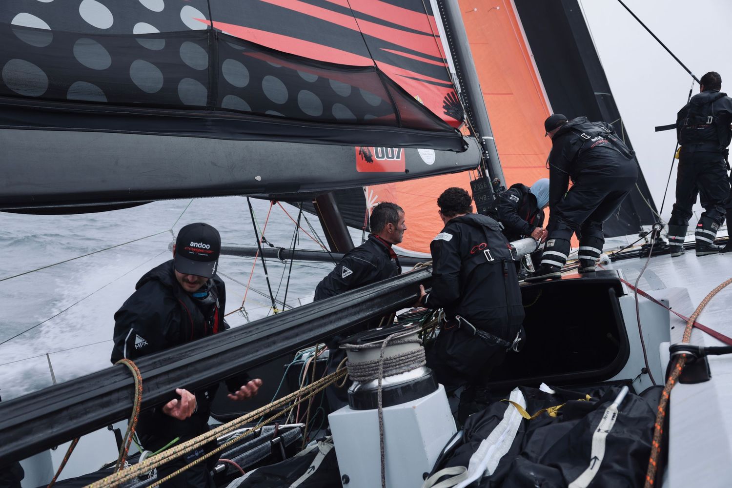 Close-up of modern racing yacht equipment and rigging against dark sails.