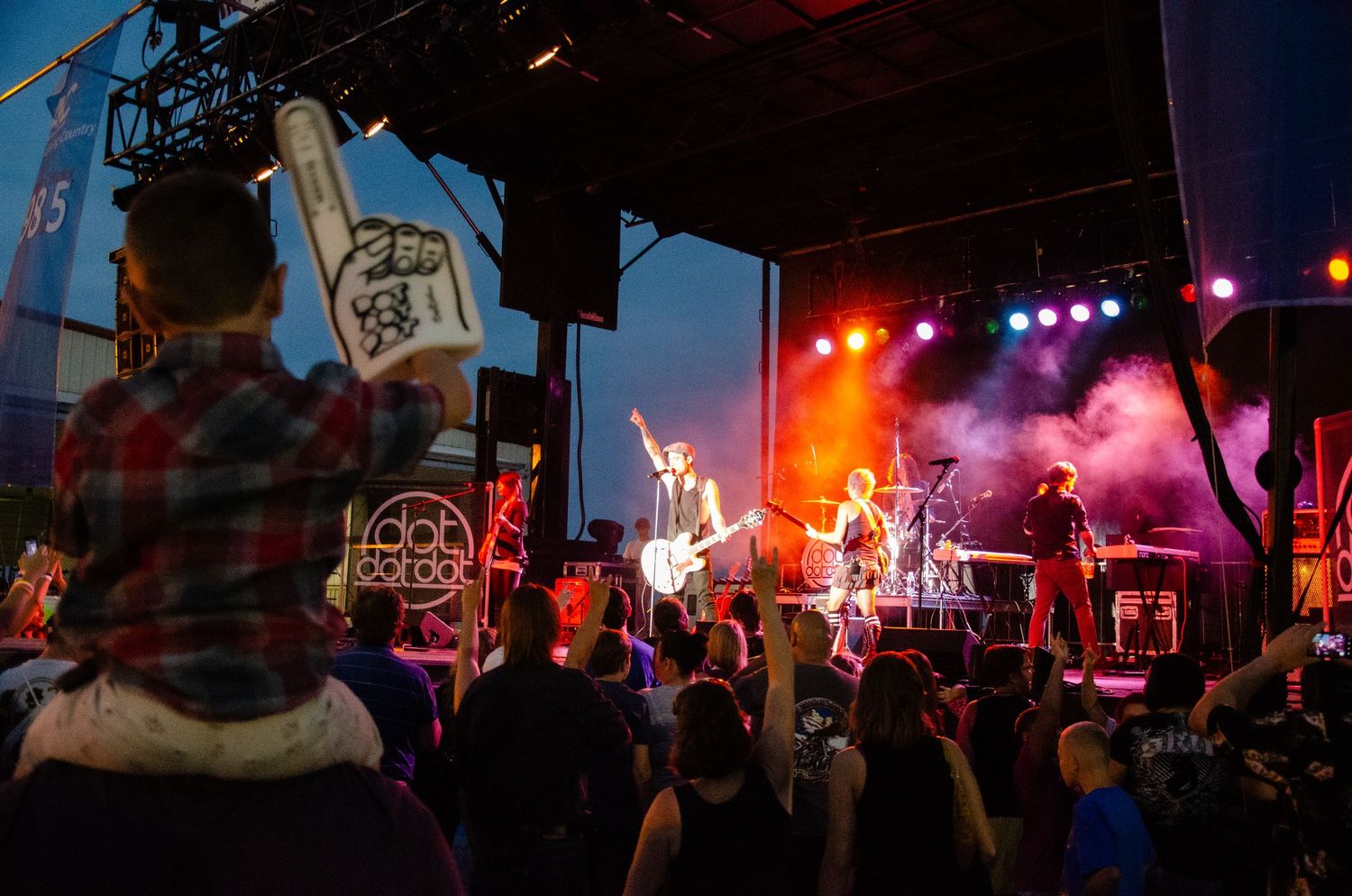 Colorado Concert performers on stage with colorful lighting and crowd silhouettes visible during a live music performance.