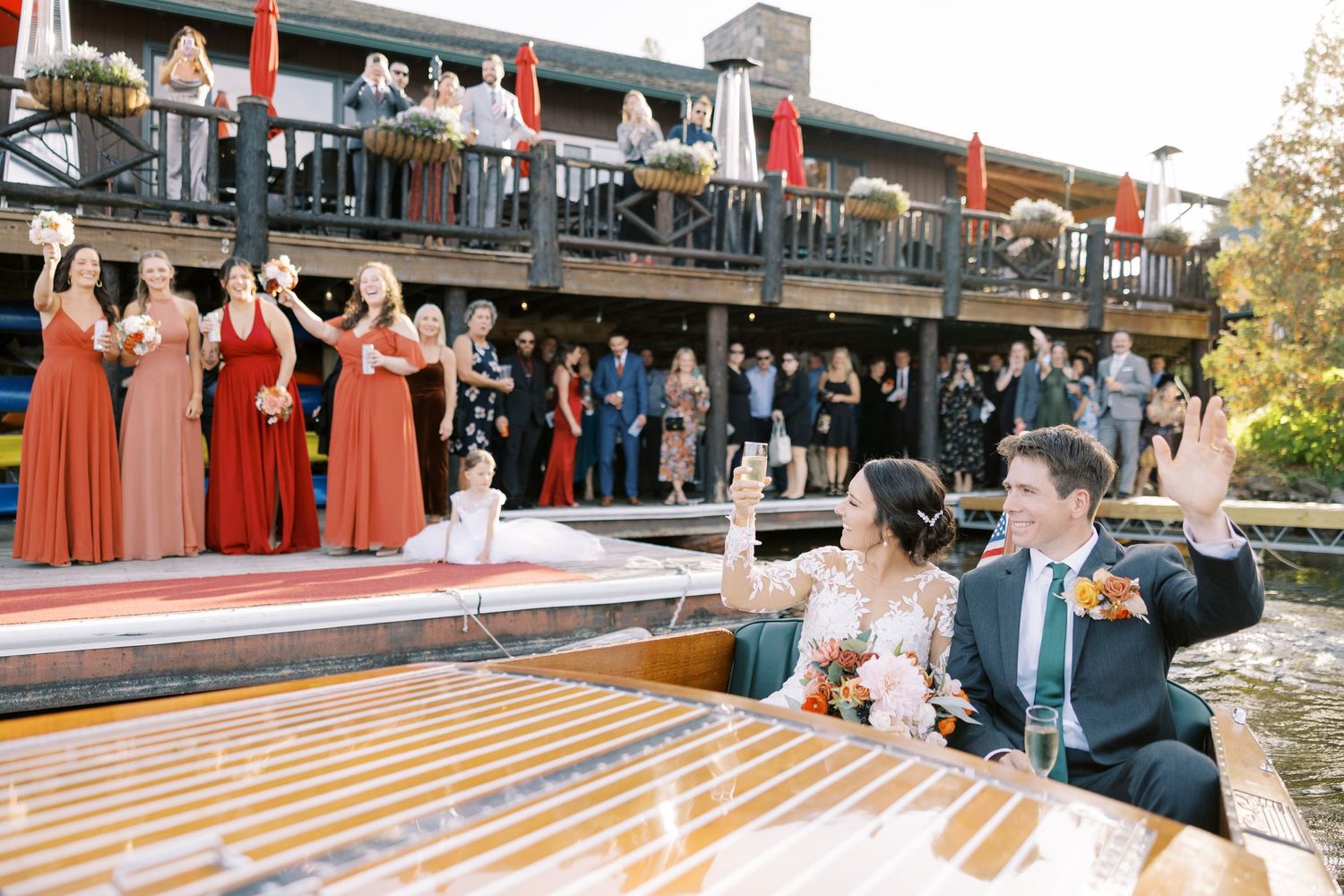 Wedding guests send off a bride and groom on a Chris-Craft boat on Lake Placid in the ADKs.
