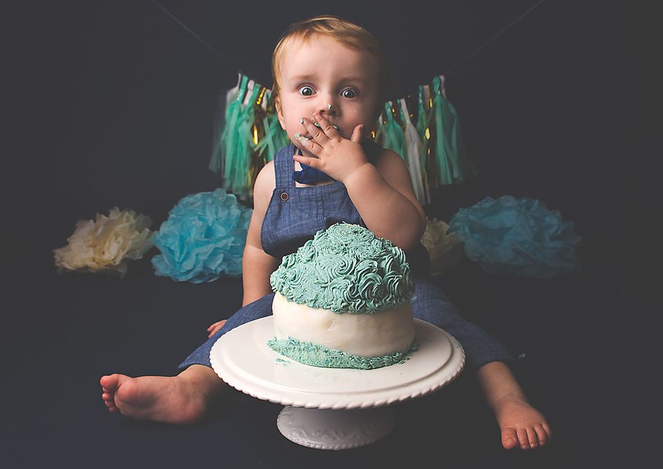 A series of cake smash photos showing a mint green frosted cake being enjoyed against a dark background.