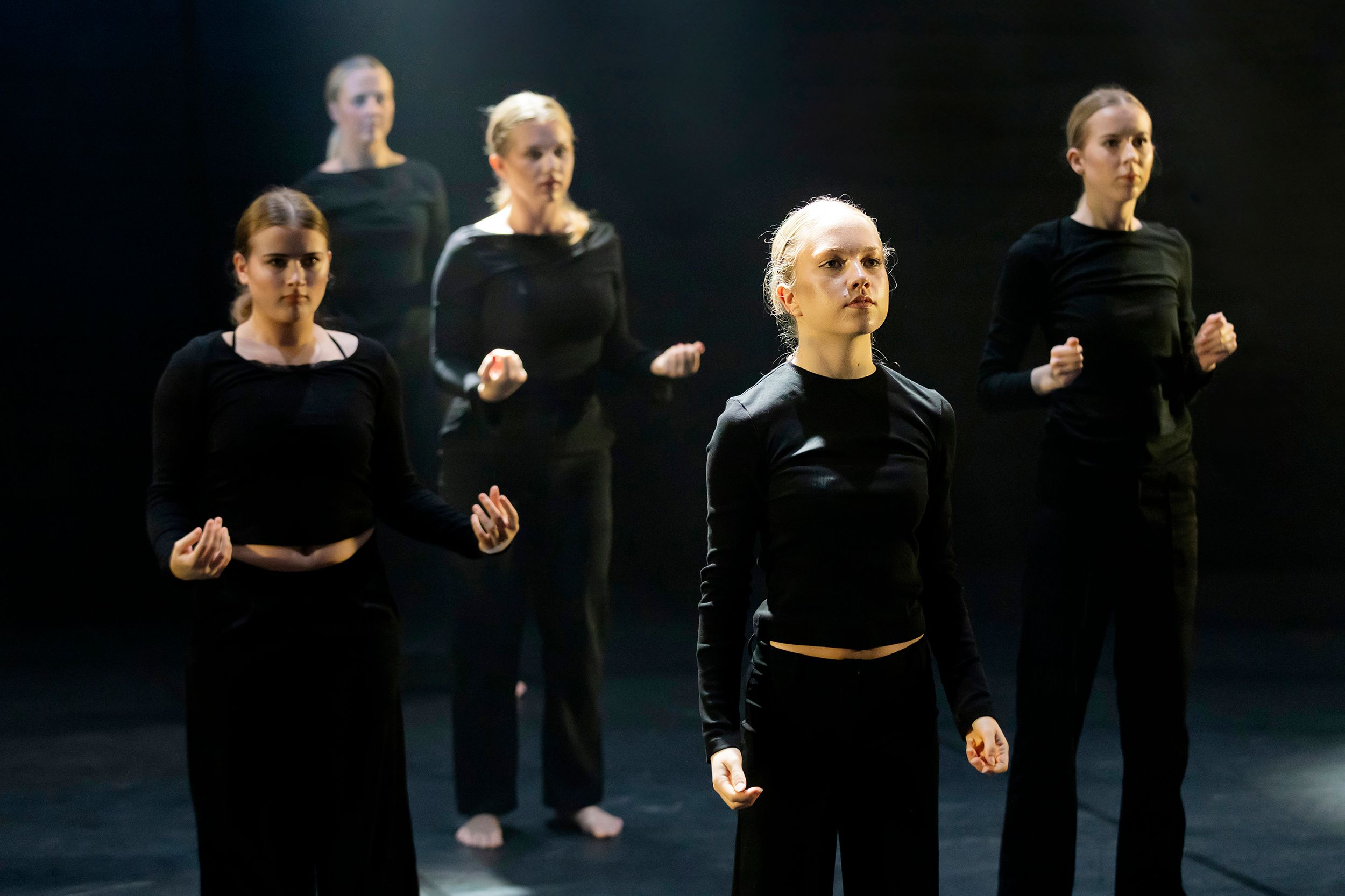Dansdag i Karlstad på Arenan. Dansare framför varandra med mörk bakgrund.