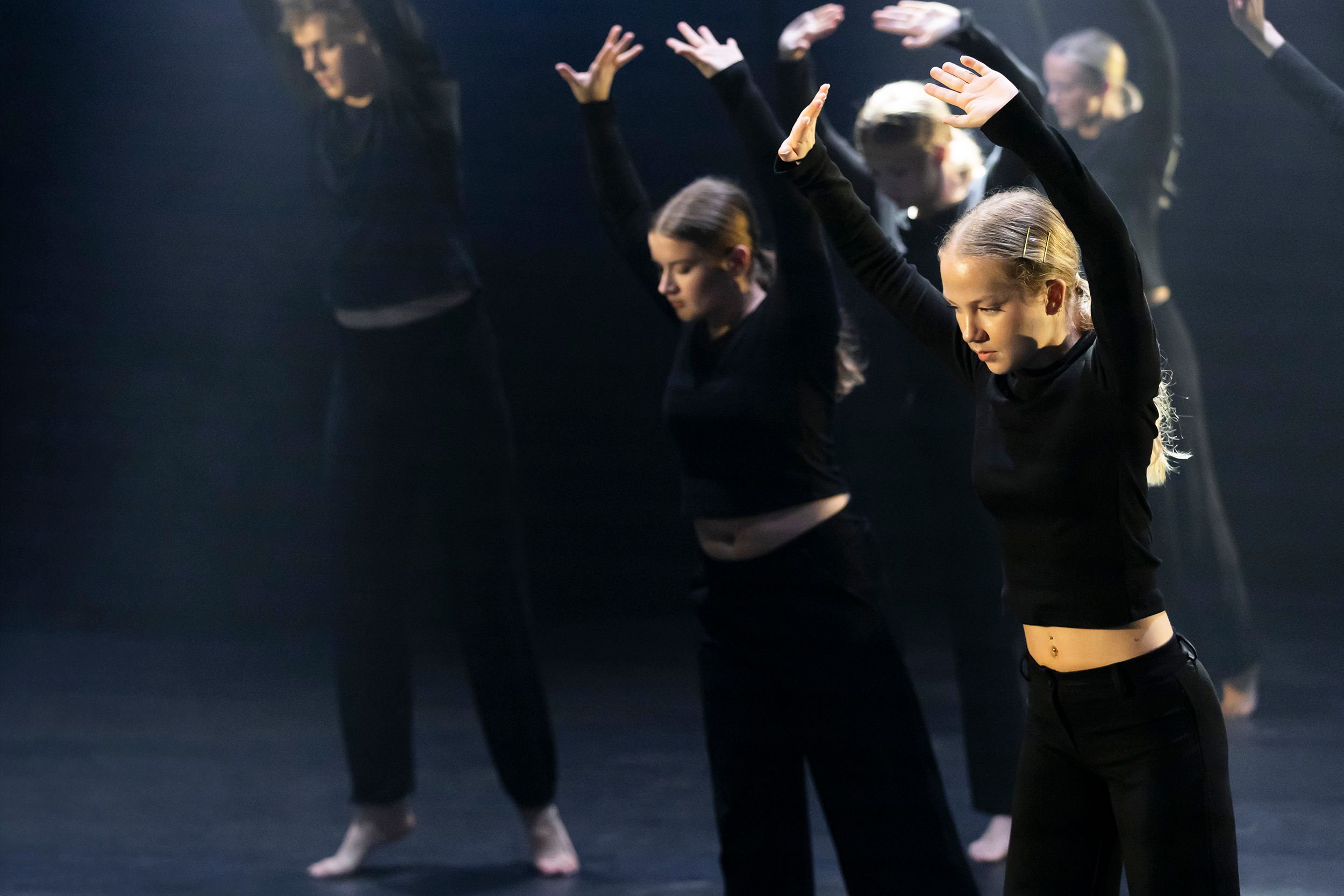 Dansdag i Karlstad på Arenan. Dansare framför varandra med mörk bakgrund.