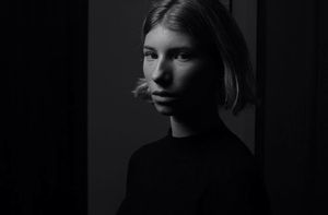 A series of black and white portrait photographs showing dramatic side lighting and shadows against dark backgrounds.