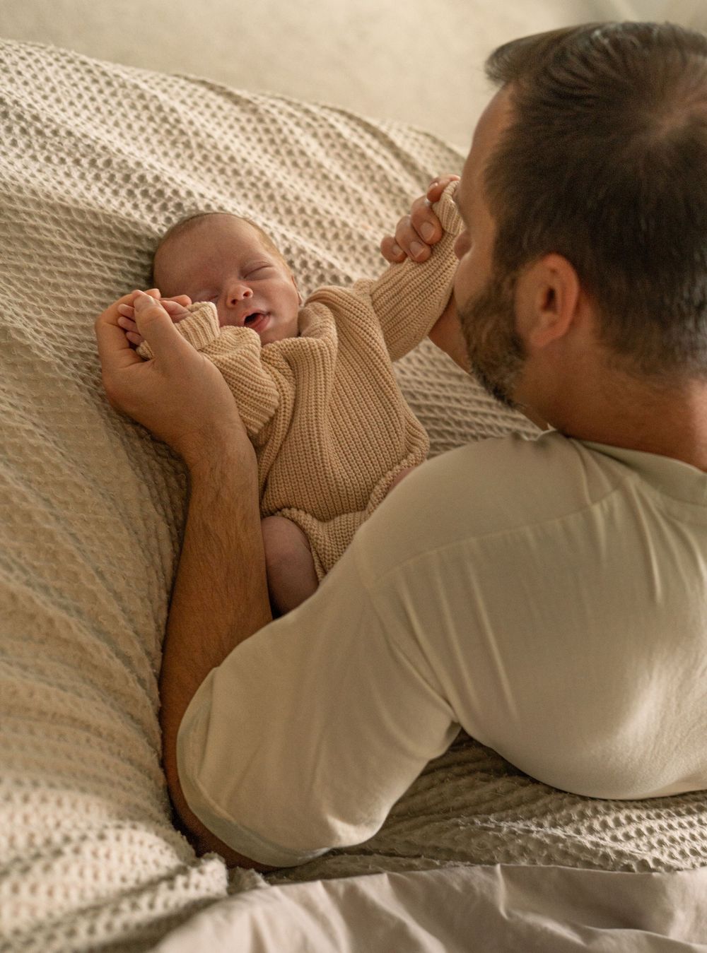 A series of images showing someone sleeping peacefully in bed with white bedding and a knit sweater.
