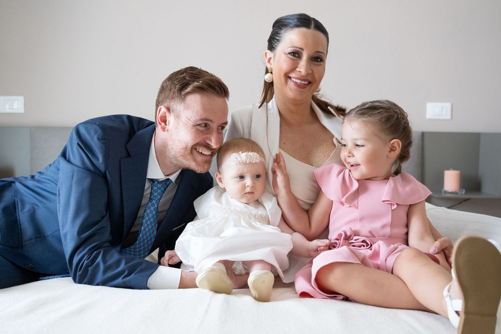 Family members share intimate moments together while looking at photos in a bright modern room.