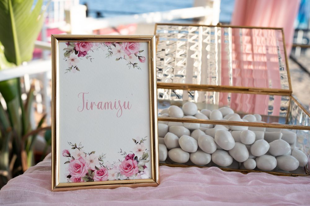 Romantic wedding decor collage featuring pink floral arrangements, macaron displays, and elegant signage in gold frames.