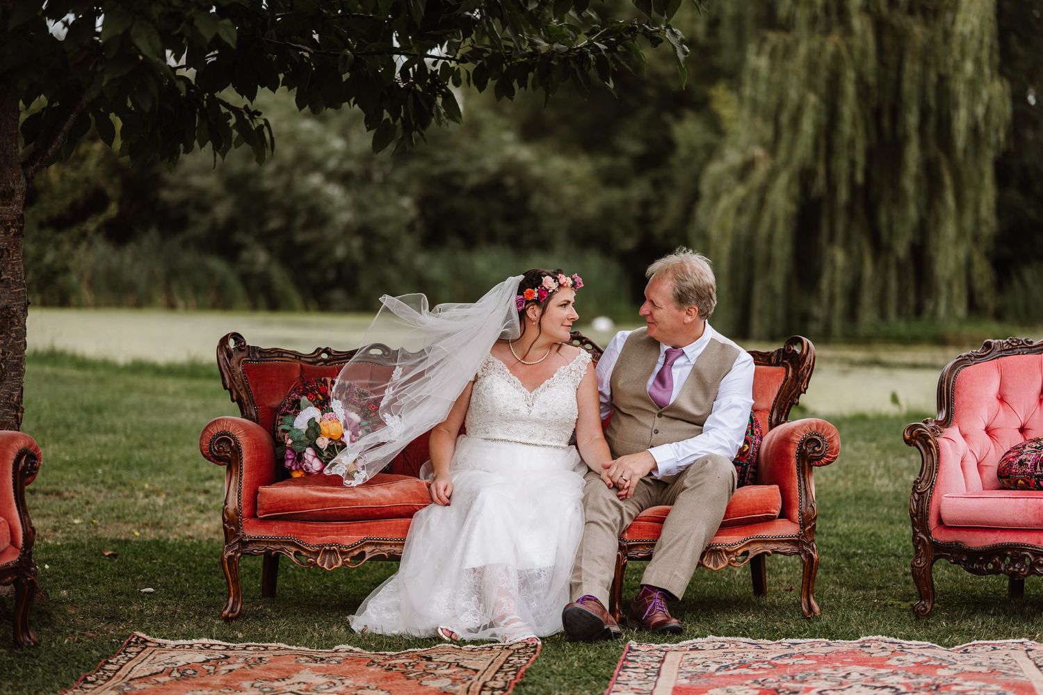 Bride and Groom sit on seat at the Waterside Country Barn and Mill, near Taunton.