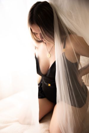 A series of four artistic boudoir photos showing a person wearing black lingerie with flowing white veil in soft lighting.