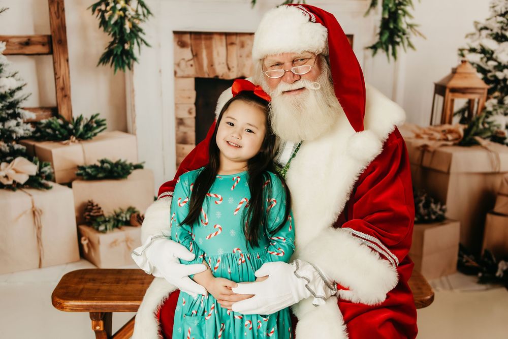 A festive holiday photo session in a cozy studio decorated with greenery and warm lighting.