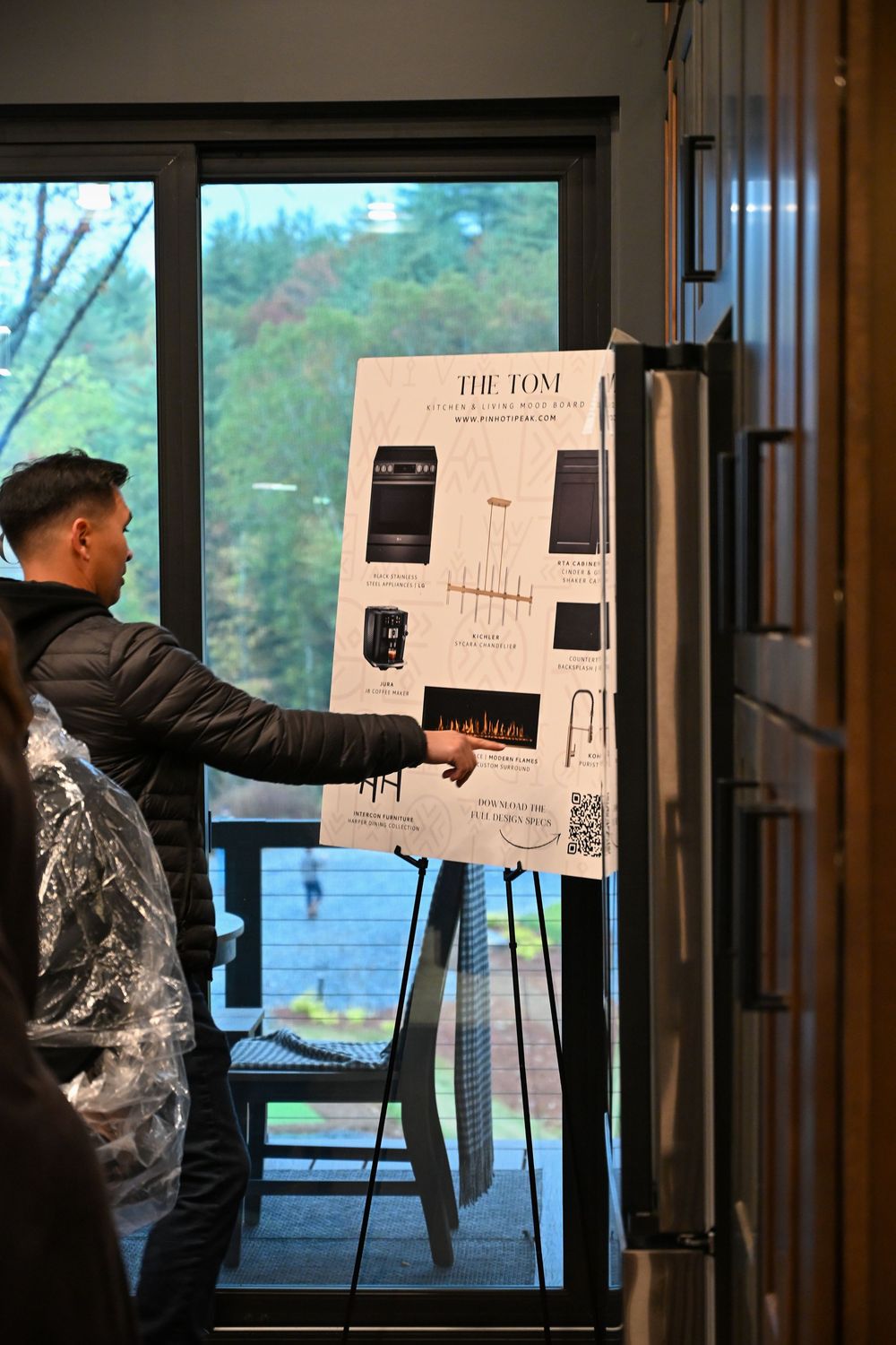 Multiple presentation boards displayed on easels in a dimly lit room with large windows.